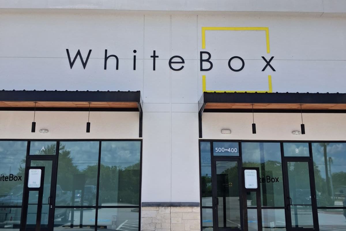 The WhiteBox storefront with its black logo and yellow box mark above two glass entrances